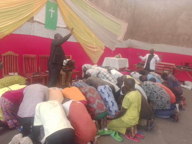 Group of young adults holding red Bibles, gathered outside a building, representing chaplaincy work